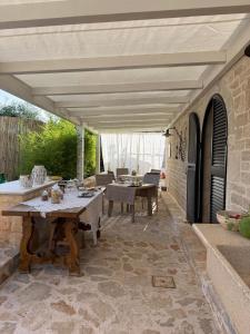 an outdoor patio with a table and chairs and awning at I Trulli di Anna in Locorotondo