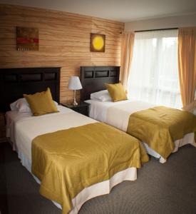 Habitación de hotel con 2 camas y ventana en Madero Aysen ApartHotel en Coyhaique