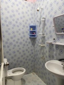 a bathroom with a toilet and a sink at Cozy Comfy 2 in Hithadhoo