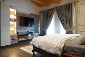 a bedroom with a bed with a fireplace and a television at ZAR Luxury Suites in Murree