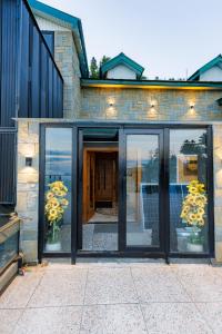 a house with glass doors in front of a building at ZAR Luxury Suites in Murree