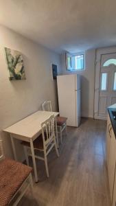 a small kitchen with a table and a refrigerator at Olga 112 in Bar