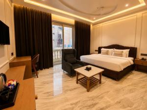 a hotel room with a bed and a chair at The S Crown Somnath in Somnath +52 photos
