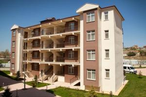 an apartment building with balconies and a yard at Safa Sorgun Thermal Hotel Wellness & SPA in Sorgun