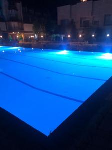 a swimming pool with blue lights at night at Lesnasr chalet apartments in Al ‘Aqabah