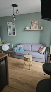 a living room with a blue couch and a table at Le coeur de Mers in Mers-les-Bains
