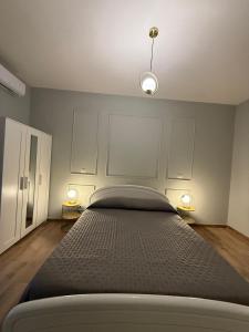 a bedroom with a large bed with two lamps at Placanica Apartment in Calitri