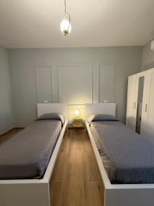 a bedroom with two beds and a lamp on the floor at Placanica Apartment in Calitri
