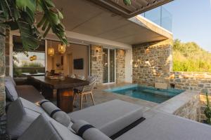 a patio with a swimming pool and a house at Gialova Hills - Luxury Villa with Private Pool, Sauna, Garden & Seaview in Gialova