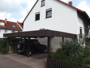 un coche aparcado bajo una cochera delante de una casa en Feworeinhard en Espira