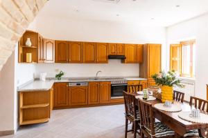 a kitchen with wooden cabinets and a table with chairs at Casa Bottega in San Salvo +27 photos
