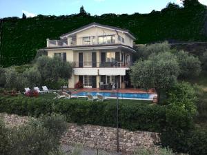 a large house with a swimming pool in front of it at Villa Cà bianca in Torri del Benaco