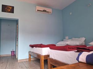 two beds in a room with blue walls at Mantan Stay in Tadri