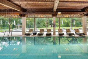 a swimming pool with chairs in a building at Hotel Krainerhütte in Baden
