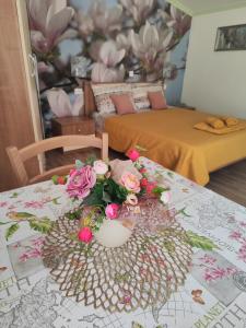 a table with a vase with flowers on it at Rooms Katarina in Poreč