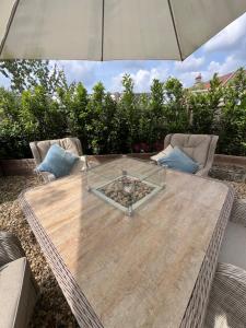 a wooden table with an umbrella on a patio at Highcroft House in Corsham