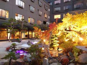 a garden in front of a building with lights at Tokigasane in Kaga