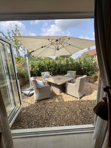 a patio with a table and chairs and an umbrella at Highcroft House in Corsham