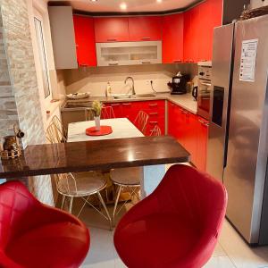 a kitchen with red cabinets and a table with red chairs at Bela & Mare in Blace