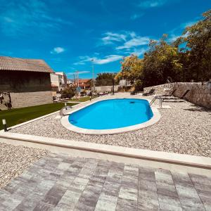 a swimming pool in a yard with a stone wall at Bela & Mare in Blace