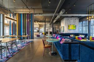 a lobby with a blue couch and tables and chairs at Aloft by Marriott Green Bay in Green Bay