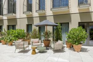 a patio with chairs and an umbrella in front of a building at AC Hotel Sants by Marriott in Barcelona