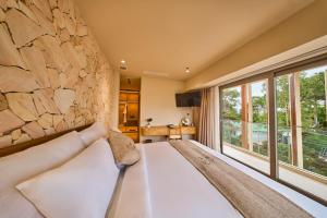 a bedroom with a large stone wall and a bed at Olive Hotel Da Lat in Da Lat