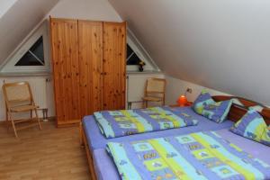 ein Schlafzimmer mit einem Bett und zwei Stühlen darin in der Unterkunft Ferienhof Lafrenz in Cuxhaven