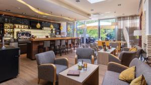 a restaurant with chairs and tables and a bar at Hotel Krainerhütte in Baden