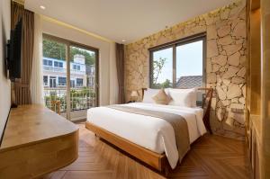 a bedroom with a large bed and a large window at Olive Hotel Da Lat in Da Lat