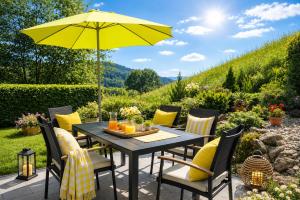 a table and chairs with a yellow umbrella at Alpinum Residence Lungau Ferienwohnung mit Garten in Tamsweg
