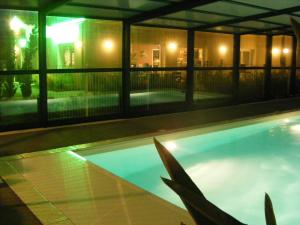 a swimming pool at night in a house at Auberge De Moricq in Angles