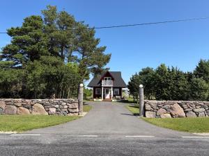 a house with a stone wall and a road at Orjaku Sadamavaade in Orjaku