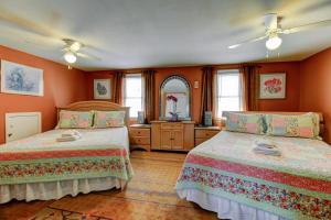 two beds in a room with orange walls at Williams Gate Bed & Breakfast Private Suites in Niagara-on-the-Lake