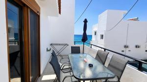 a balcony with a table and chairs and the ocean at Azure Seaside Living in Kardamaina