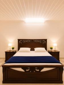 a bedroom with a large bed with a blue bedspread at Canopy Court Farmhouse Murree in Bhurban