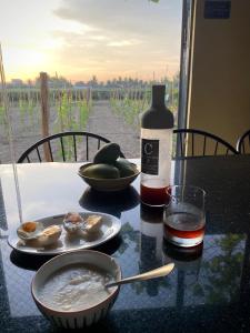 a table with a plate of food and a bottle of wine at Nhà Yên Homestay Phan Rang in Kinh Dinh