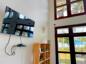 a room with a tv on the wall and a window at Surf Bay Villa Weligama in Pelena