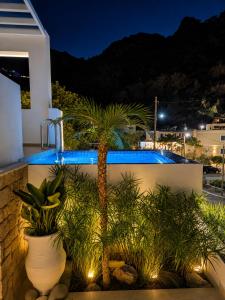 a villa with a swimming pool at night at Enilion Luxury Suites in Kyra Panagia