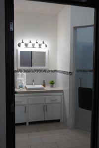 a bathroom with a sink and a mirror and a shower at Casa Del Pueblo in Teotitlán del Valle