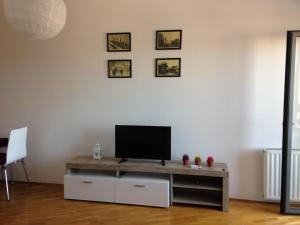 a living room with a tv on a white wall at L&B Studio Apartment in Pristina