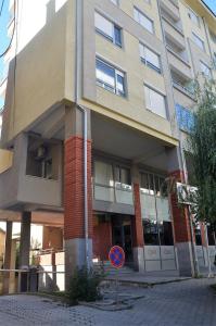 un edificio con una señal azul delante de él en L&B Studio Apartment, en Pristina