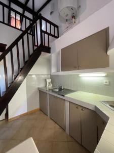 a kitchen with a sink and a staircase at Locations proche de la plage de Barcaggio accessible par une piste en terre de 3,5 kilometres de Tizzano en voiture in Sartène