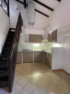 an empty kitchen with a staircase in a room at Locations proche de la plage de Barcaggio accessible par une piste en terre de 3,5 kilometres de Tizzano en voiture in Sartène