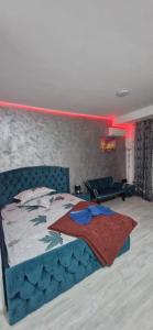 a bedroom with a bed with a blue head board at apartament 1 camera in Roşu
