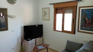 a living room with a couch and a flat screen tv at Casita Zagra in La Carrera de la Viña