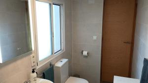 a bathroom with a white toilet and a window at Casita Zagra in La Carrera de la Viña +30 photos