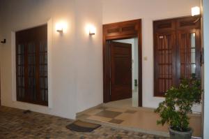 a hallway with two doors and a potted plant at Cinnamon Villa Kandy in Kandy