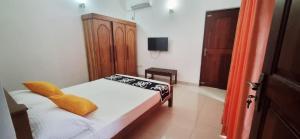 a small bedroom with a bed and a wooden cabinet at Cinnamon Villa Kandy in Kandy