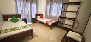 a small room with two beds and a shelf at Cinnamon Villa Kandy in Kandy